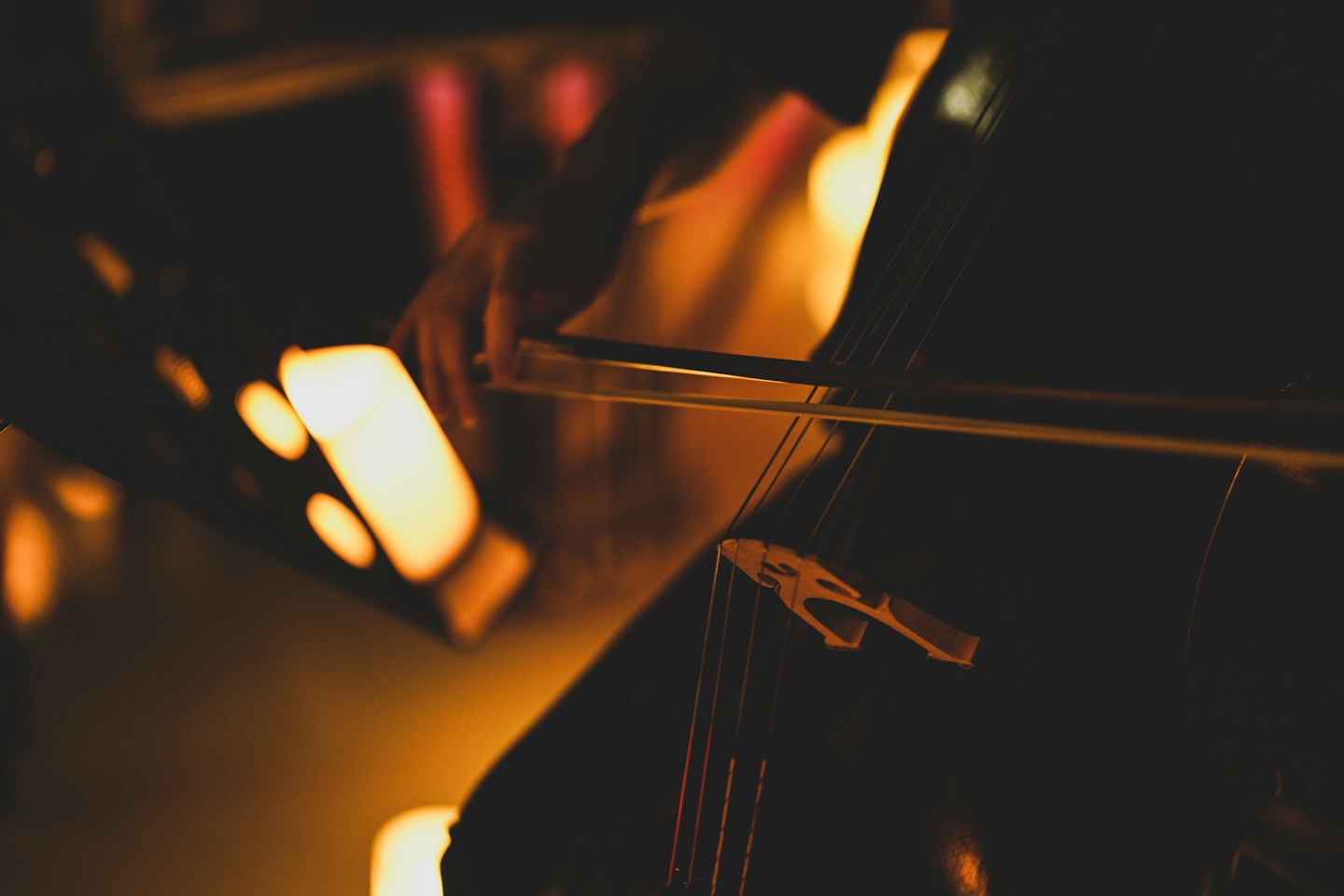 Hände eines Musikers, die einen Kontrabass auf der Bühne streichen.